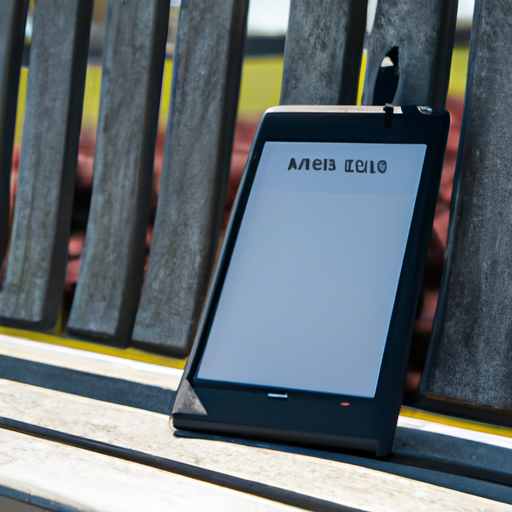 A sunny park bench with a kobo clara 2e on it showing a readable screen despite the bright outdoor conditions